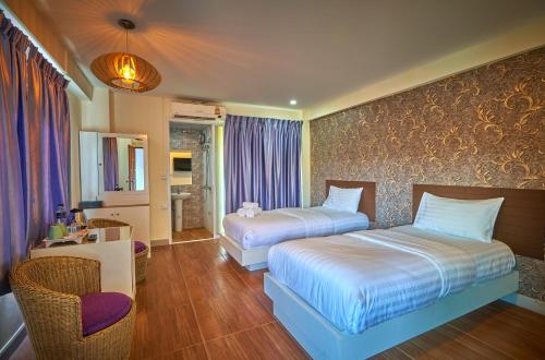 曼谷Sweetloft Hotel Don Muang的酒店客房,配有两张床和椅子