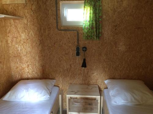 BeilenTrekkershut的一间卧室设有两张床、一个窗口和一张桌子