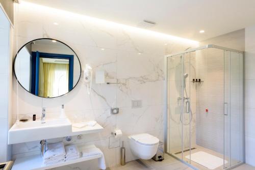 采蒂涅Hotel Gradska Cetinje的浴室配有盥洗池、卫生间和镜子。
