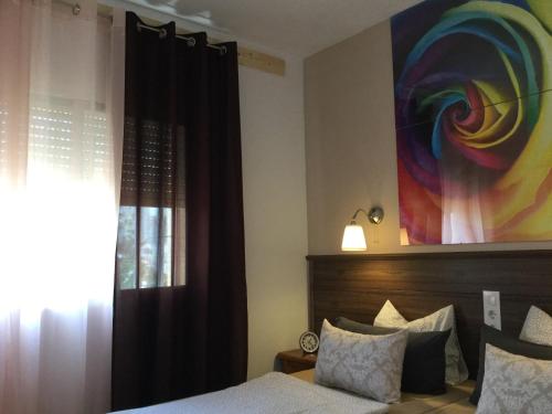德尼亚Apartman Dénia的卧室配有一张床,墙上挂有绘画作品