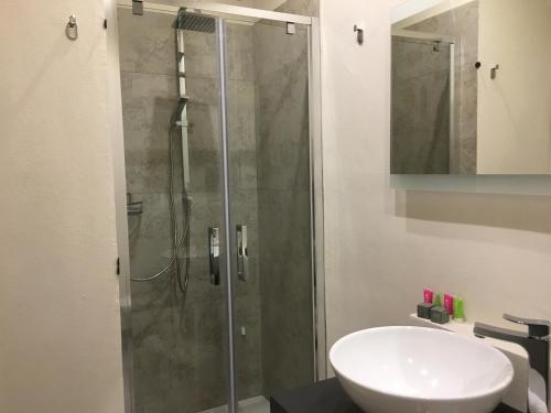 马达莱纳Dimora Conte的一间带玻璃淋浴和水槽的浴室