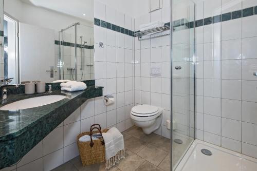 特拉森海德Upstalsboom Hotel Strandidyll的浴室配有卫生间、盥洗盆和淋浴。