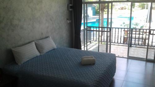 盼武里山景度假酒店的一间卧室配有一张床,享有游泳池的景色