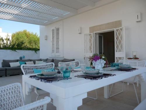 特拉尼Villa Matinella的白色的用餐室配有白色的桌椅