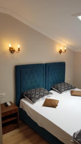 康斯坦察Pensiunea La Iani的一间卧室配有两张带蓝色床头板的床