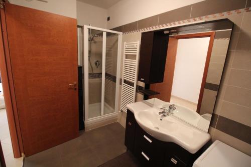 阿尔玛·迪·塔吉亚Appartamento Geranei的浴室配有白色水槽和淋浴。