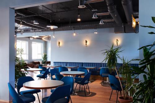 雷克雅未克ODDSSON Hotel的一间配备有桌子和蓝色椅子的用餐室