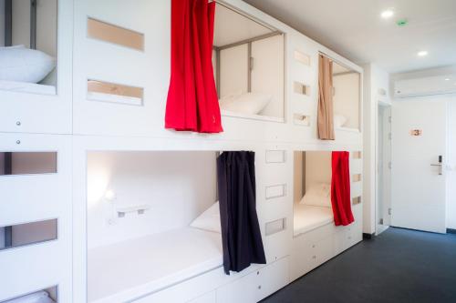 贝尔格莱德Good People Design Hostel的一间白色墙壁和红色窗帘的房间