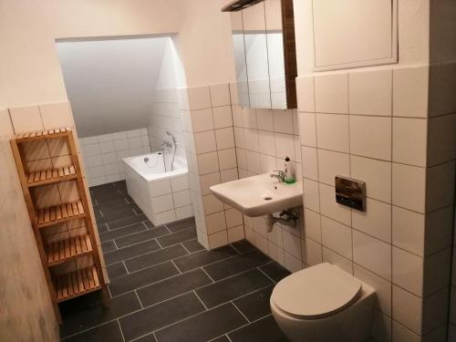 阿尔特费尔Ferienwohnungen Poppelvitz的白色的浴室设有卫生间和水槽。