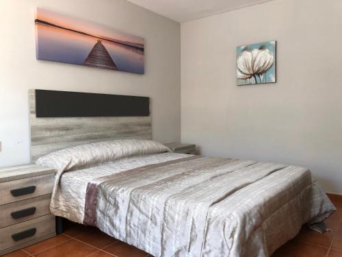 佩尼斯科拉Casa Pareada en Peñiscola的卧室配有一张床,墙上配有电视。