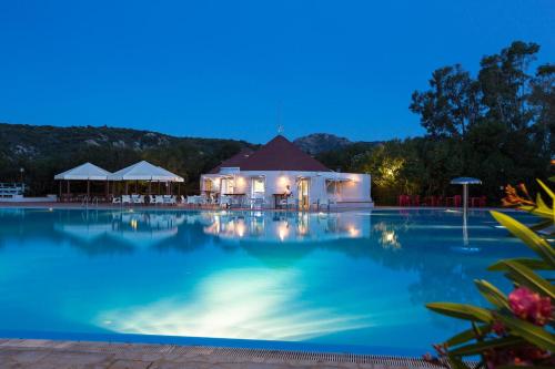 库尼亚纳Cugnana Porto Rotondo Bungalows - Camping的享有游泳池的夜间景致
