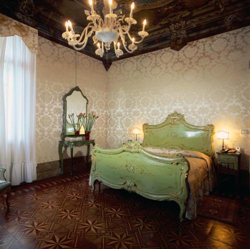 威尼斯阿巴德萨豪华酒店的一间卧室配有一张绿色的床和吊灯。