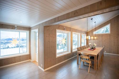 松达尔Rolfhytta - Fosskamben 19的一间带木桌和窗户的用餐室