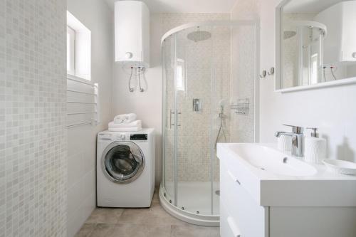 伊佐拉Apartment Fresh - Parking included的白色的浴室设有洗衣机和水槽。