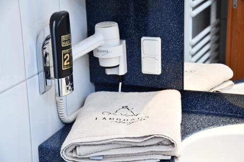 LengedeLANDHAUS LENGEDE Hotel的浴室设有电话和台面毛巾
