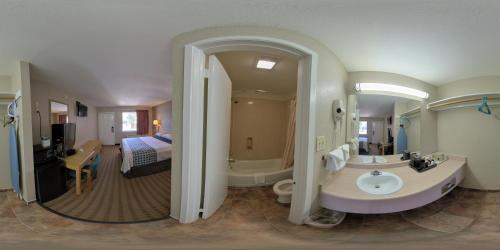 圣安东尼奥River Inn Motel的一间带水槽和浴缸的浴室以及一张床