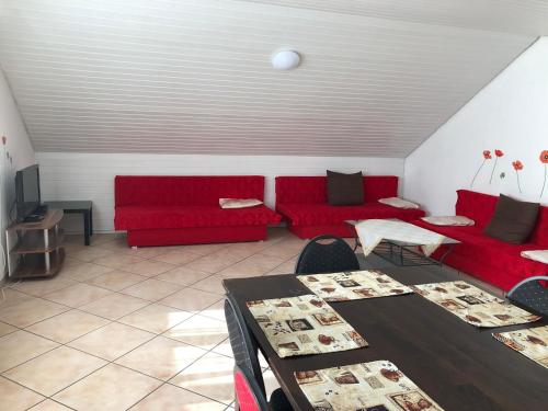 OststeinbekApartment BLN的客厅配有红色的沙发和桌子
