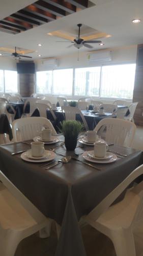 马德罗城Hotel Tampico Express的一间带桌子和白色椅子的用餐室