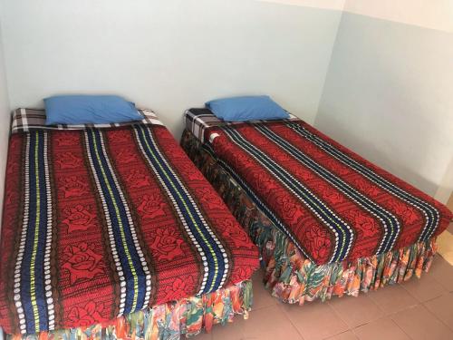 峇都丁宜巴巴海滨宾馆的两张睡床彼此相邻,位于一个房间里