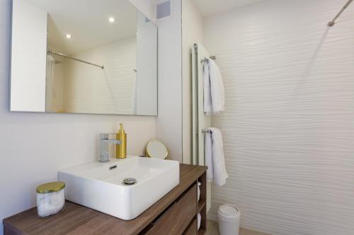里昂7e Ciel - Rooftop Panoramique的浴室设有白色水槽和镜子