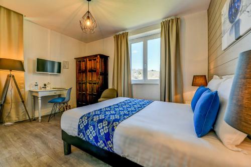 GanLogis Hostellerie du Neez的配有一张床和一张书桌的酒店客房