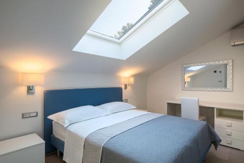 诺维格勒伊斯特拉Apartmani Mare verde的一间卧室设有蓝色的床和天窗