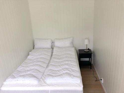 勒尔达尔Saltvold leilighet nr1的一张白色的床,位于带边桌的房间里
