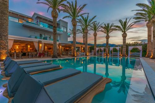 玛利亚Drossia Palms Hotel and Nisos Beach Suites的棕榈树游泳池以及酒店