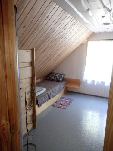 巴尔维Jēkaba māja的一间小房间,阁楼上配有一张床