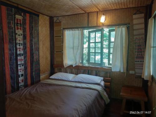 清莱班苏安杨特拉乡村民宿的一间小卧室,配有床和窗户