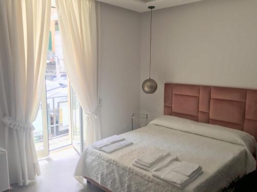那不勒斯“A piazzetta”的一间卧室配有一张床,上面有两条毛巾