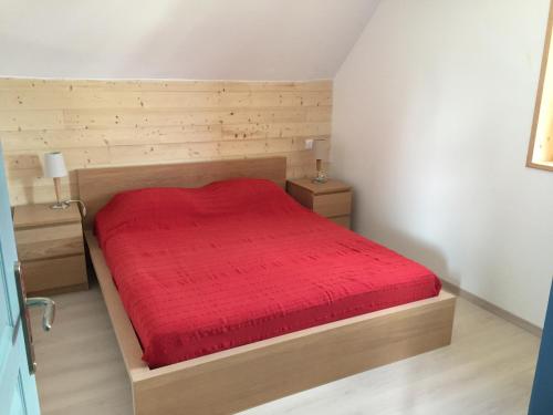普卢阿尔内APPT T2 PROCHE PLAGE的一间卧室配有一张带红色床罩的木床