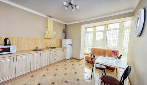 伊万诺-弗兰科夫斯克Apart Reserve Sloboda Klassik的厨房配有桌椅和冰箱。