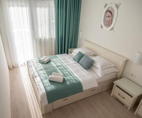 默主歌耶Gloria Apartments 1的一间卧室配有一张带绿床单和枕头的床。