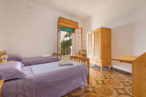 莱乌卡Villino FINIS TERRAE - S.M. di LEUCA的一间卧室设有两张床和窗户。