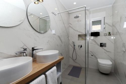 马卡尔斯卡Apartments Pivac的一间带水槽、卫生间和镜子的浴室