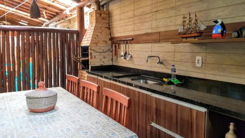 伊塔齐米林Linda Casa de Praia em Itacimirim的厨房配有水槽和桌椅