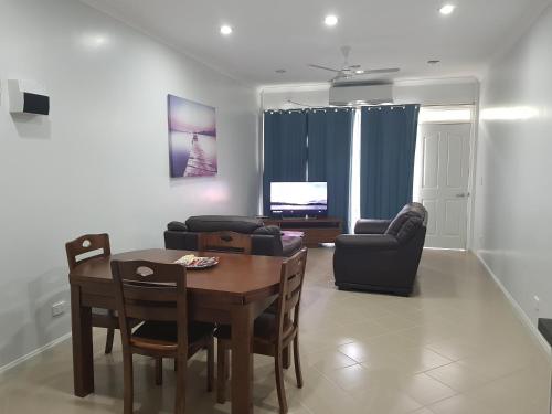 霍尼亚拉Prestige Apartments - Solomon Islands的客厅配有桌椅和电视。