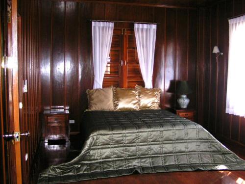 班杜清莱住宿加早餐酒店的一间卧室配有木墙床