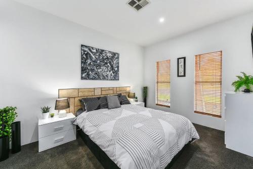 芒特甘比尔KENNEDY EXECUTIVE TOWNHOUSE的白色卧室设有一张大床和两个窗户