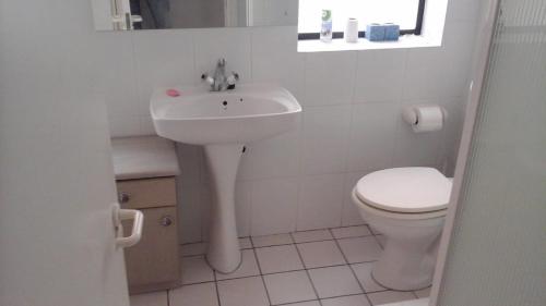 布鲁堡史特兰Shalom beach house的白色的浴室设有卫生间和水槽。