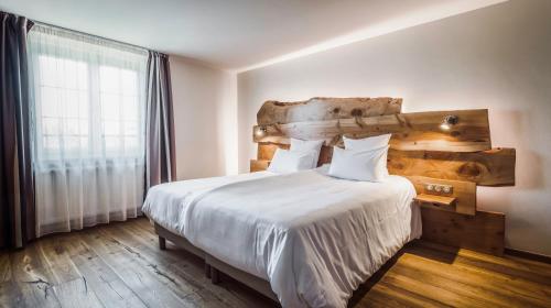CleebourgHotel Keimberg的一间卧室配有一张大床和木制床头板