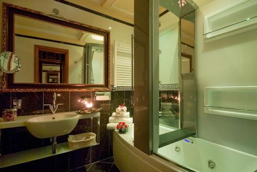 罗马罗马曼弗雷迪套房酒店的浴室配有盥洗盆、镜子和浴缸