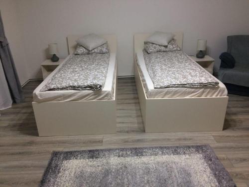 锡比乌Warm Studio的配有两张单人床的客房,铺有地毯