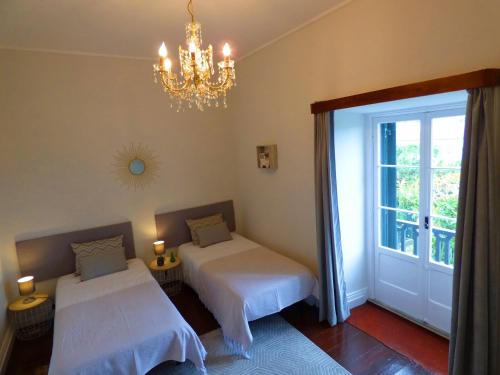 蓬塔德尔加达Quinta Do Solar - Exclusivo Perfeito para Famílias的一间卧室配有两张床和吊灯。