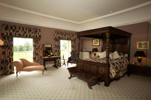 BallyraggetGrange Manor的一间卧室配有一张天蓬床和一把椅子