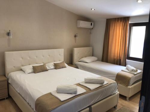 乌尔齐尼Days Inn Apartments的一间卧室设有两张床和窗户。