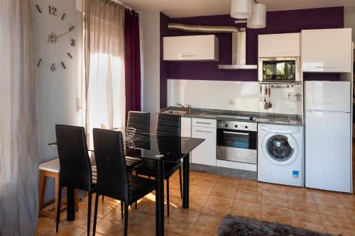 米尼奥Apartamento A pie de Playa的带餐桌的厨房和带洗衣机的厨房