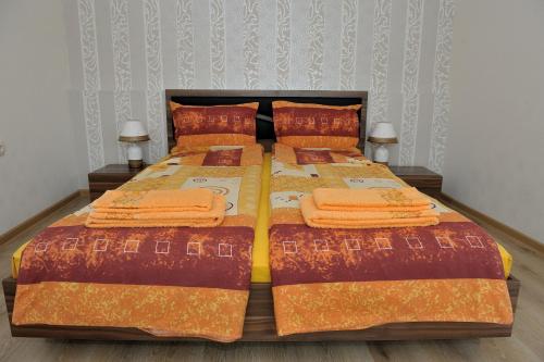贝尔科维察The House of Petar Levski的一间卧室配有带橙色床单和枕头的床。