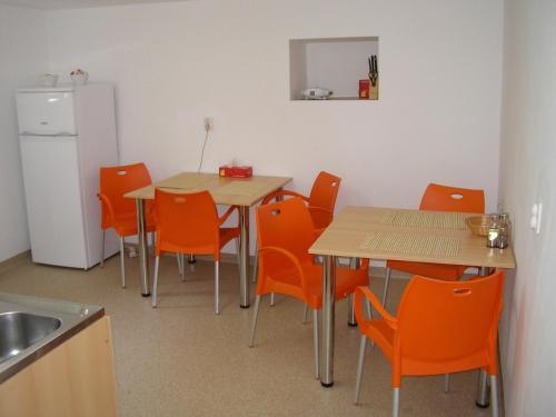 克卢日-纳波卡沙达旅馆的厨房配有2张桌子、橙色椅子和冰箱